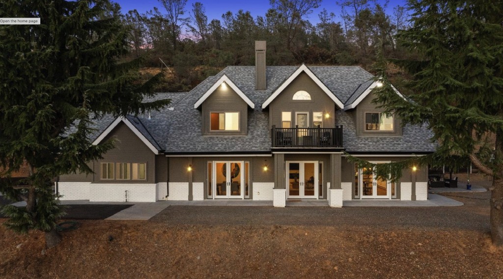 Luxury Two Story Dark Gray Craftsman Home with White Brick Trim and Balcony at Twilight.jpg