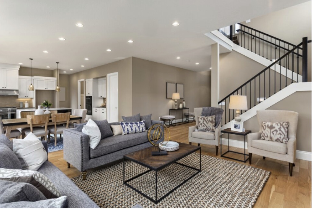 Spacious Open Concept Home Interior with Grey Sofas Staircase and Kitchen View.jpg