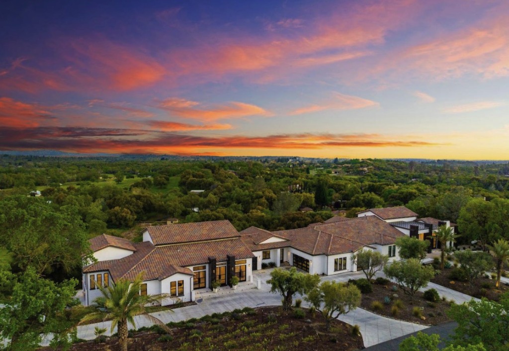 Stucco Suburban House Exterior with Brick Trim Gable Awning and Garage at Sunset.jpg