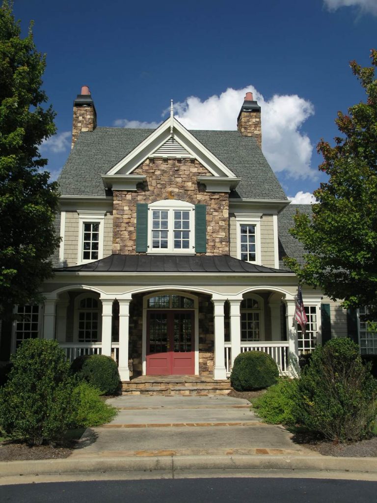 Two Story Craftsman Home with Stacked Stone Facade Red Front Doors and Wraparound Porch.jpg